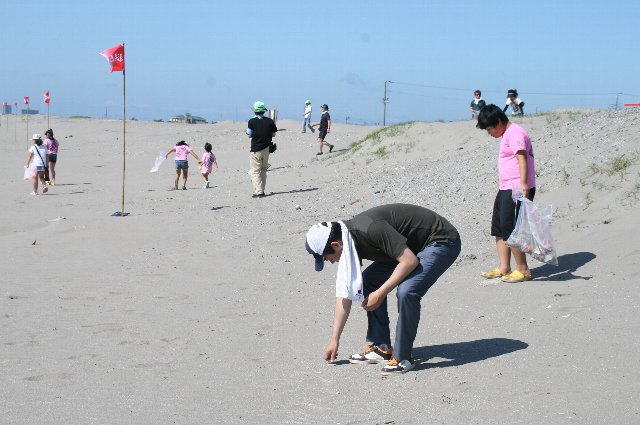 参加者と一緒に海岸清掃をする市長