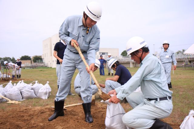 土のう作りをする町長