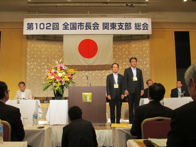 総会で紹介される埼玉県白岡市の小島市長（左）と金坂市長（右）
