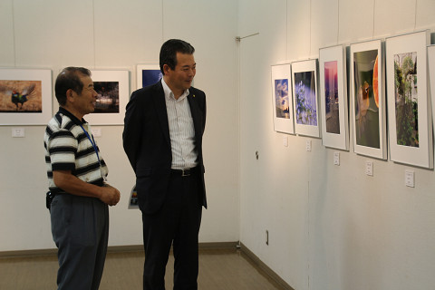 説明を受けながら写真展を鑑賞する市長