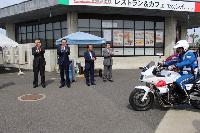 街頭パトロールに出発する警察車両を見送る市長の写真