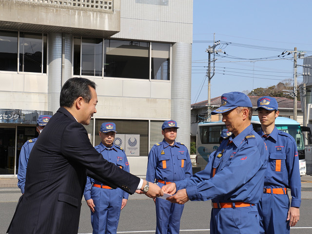 市長から北田団長へ引き渡し書を交付　