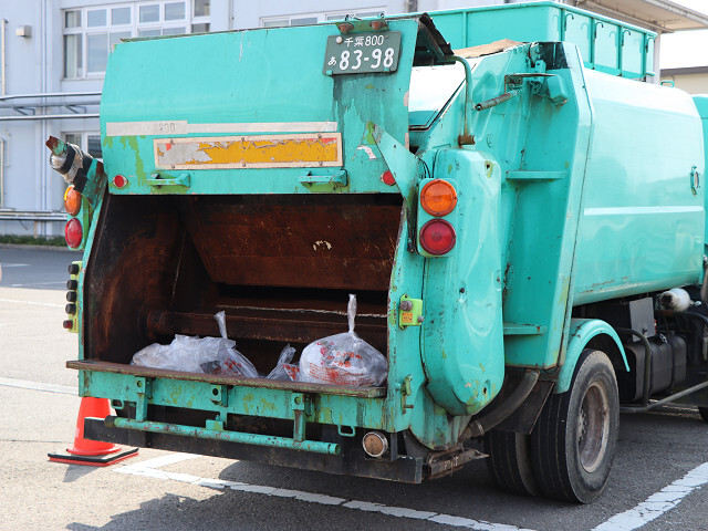収集車に集められる多くのごみの写真