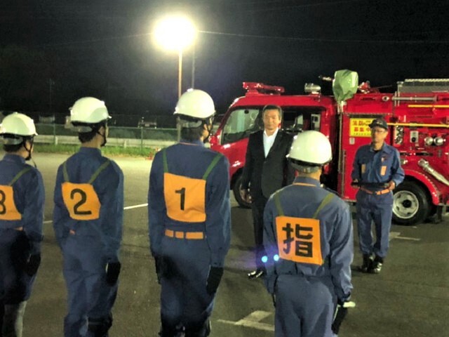 訓練に励む団員を激励する市長の写真